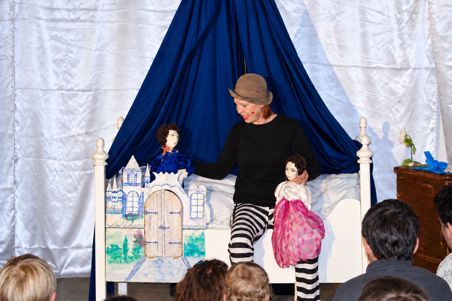 Die Spielerin mit den beiden Prinzessinnen-Puppen am weißen Bett, davor die Kinder